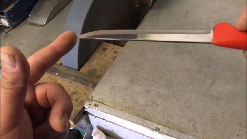Hollow grinding a knife on a professional machine